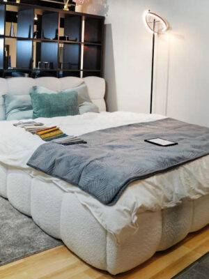 Białe łóżko tapicerowane boucle w salonie Meble Pasternak Gliwice – Galeria Reforma